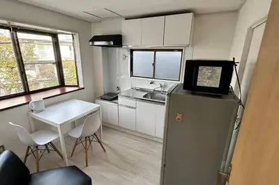 a small kitchen with a refrigerator and a table at Warmhome-hirai3F in Tokyo