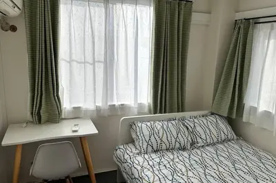 a small bedroom with a bed and a window at Warmhome-hirai3F in Tokyo