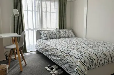 a bedroom with a bed and a desk and a window at Warmhome-hirai3F in Tokyo
