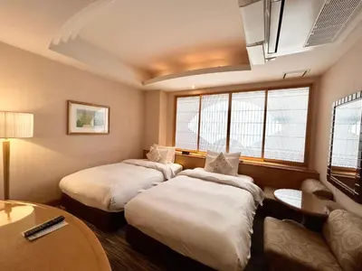 a hotel room with two beds and a table at \u30db\u30c6\u30eb\u30d4\u30e5\u30ea\u30c3\u30c4\u30a1\u30fc\u81ea\u7531\u304c\u4e18 in Tokyo
