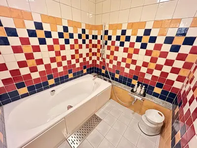 a bathroom with a white tub and colorful tiles at \u30db\u30c6\u30eb\u30d4\u30e5\u30ea\u30c3\u30c4\u30a1\u30fc\u81ea\u7531\u304c\u4e18 in Tokyo