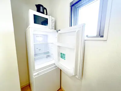 a refrigerator with its door open with a microwave inside at Shinjuku City, 2 Double Beds Apt, Free WiFi in Tokyo
