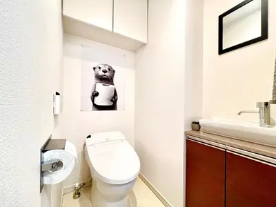 a bathroom with a toilet and a dog picture on the wall at Shinjuku City, 2 Double Beds Apt, Free WiFi in Tokyo