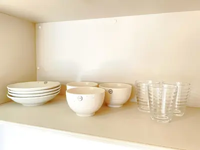 a shelf with bowls and glasses on it at Shinjuku City, 2 Double Beds Apt, Free WiFi in Tokyo