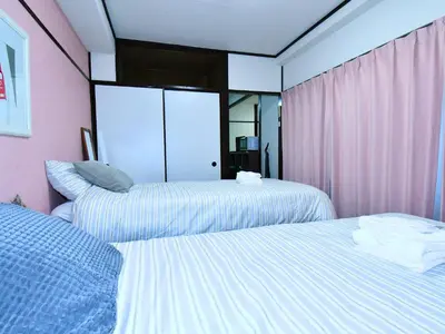 two beds in a room with pink walls and mirrors at \u5927\u68ee\u30d3\u30c3\u30b0\u30d5\u30a9\u30ec\u30b9\u30c8-Oomori Big Forest- \u7fbd\u7530\u7a7a\u6e2f \u54c1\u5ddd \u6771\u4eac\u307e\u3067\u30a2\u30af\u30bb\u30b9\u826f\u597d \u7121\u6599Wi-Fi in Tokyo