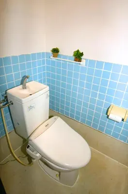 a bathroom with a toilet with a blue tiled wall at \u5927\u68ee\u30d3\u30c3\u30b0\u30d5\u30a9\u30ec\u30b9\u30c8-Oomori Big Forest- \u7fbd\u7530\u7a7a\u6e2f \u54c1\u5ddd \u6771\u4eac\u307e\u3067\u30a2\u30af\u30bb\u30b9\u826f\u597d \u7121\u6599Wi-Fi in Tokyo