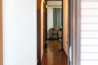 a hallway leading to a room with a table at Garfield home Shinjuku in Tokyo