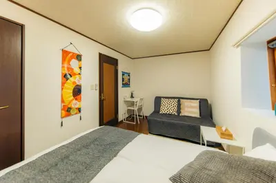 a bedroom with a bed and a chair at Garfield home Shinjuku in Tokyo