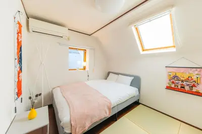 a small bedroom with a bed and a window at Garfield home Shinjuku in Tokyo