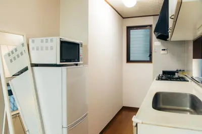 a small kitchen with a refrigerator and a sink at Garfield home Shinjuku in Tokyo