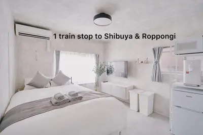 a white bedroom with a bed with shoes on it at Cosmo in Tokyo