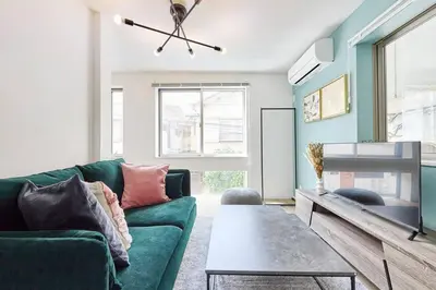 a living room with a green couch and a table at Tnw\u5317\u65b0\u5bbf4\u4e01\u76ee in Tokyo
