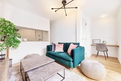 a living room with a green couch and a table at Tnw\u5317\u65b0\u5bbf4\u4e01\u76ee in Tokyo