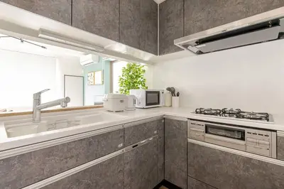 a kitchen with a sink and a microwave at Tnw\u5317\u65b0\u5bbf4\u4e01\u76ee in Tokyo