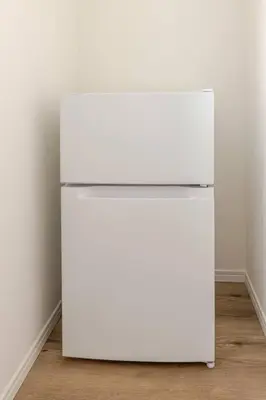 a white refrigerator in the corner of a room at Tnw\u5317\u65b0\u5bbf4\u4e01\u76ee in Tokyo