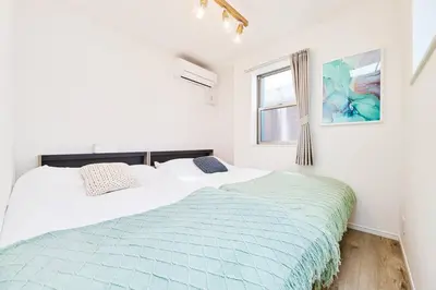 two beds in a bedroom with white walls and a window at Tnw\u5317\u65b0\u5bbf4\u4e01\u76ee in Tokyo