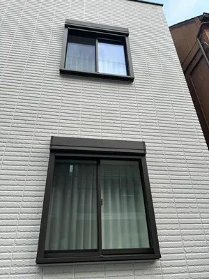 a window on the side of a brick building at Wasabi Box House - Ikebukuro Area in Tokyo