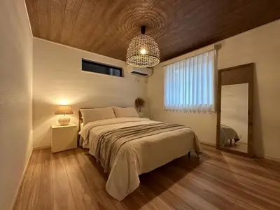 a bedroom with a large bed and a chandelier at Wasabi Box House - Ikebukuro Area in Tokyo