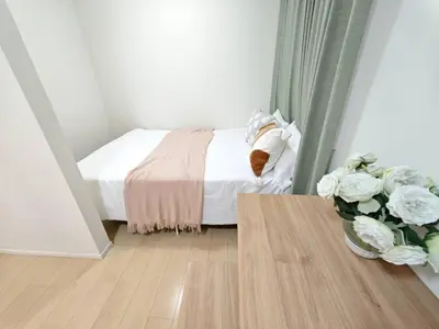 a small bedroom with a bed and a vase of flowers at Nerima house NR0250 in Tokyo