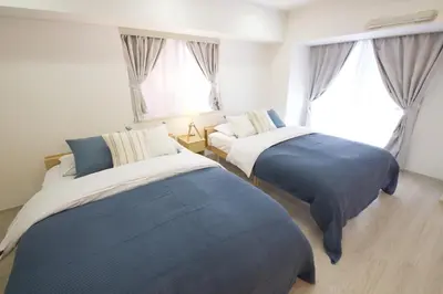 two beds sitting in a room with windows at Palais Grace Room 301 - Vacation STAY 56621v in Tokyo