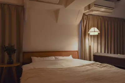 a bedroom with a bed and a lamp and curtains at Prinets Shinjuku Building - Vacation STAY 17728 in Tokyo