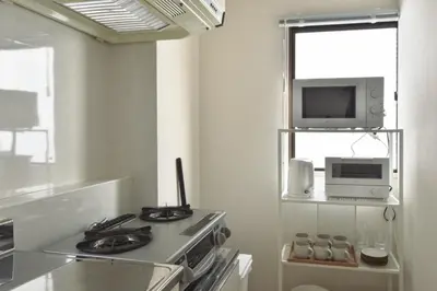 a kitchen with a stove and a microwave at Prinets Shinjuku Building - Vacation STAY 17728 in Tokyo