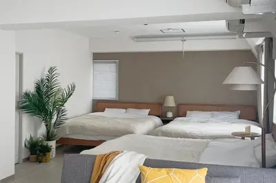 a bedroom with two beds and a potted plant at Prinets Shinjuku Building - Vacation STAY 17728 in Tokyo