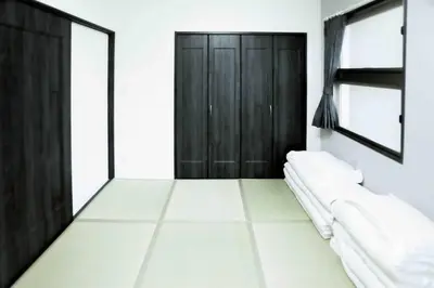 a room with a black door and a white floor at yuga hotel tokiwadai in Tokyo