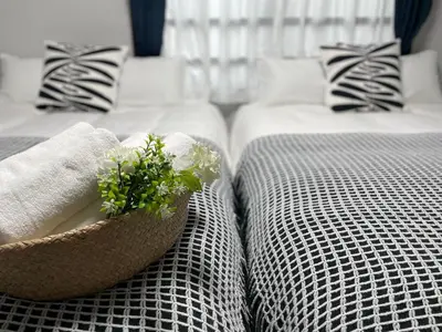 two beds with towels and a basket of flowers on them at COMMA HOUSE Otsuka 101 in Tokyo