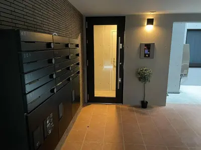 a hallway with a door and a vase with a plant at COMMA HOUSE Otsuka 101 in Tokyo