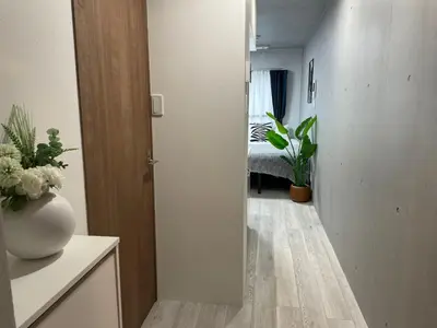 a room with a hallway with a vase on a table at COMMA HOUSE Otsuka 101 in Tokyo