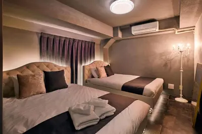 a hotel room with two beds and a window at Spacious 80sqm Apt near Shibuya Crossing, 8 min walk to Shibuya Station in Tokyo