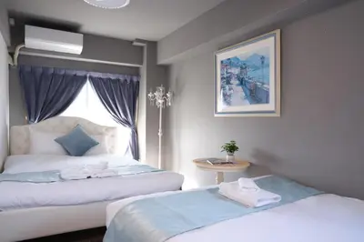 a hotel room with two beds and a window at Spacious 80sqm Apt near Shibuya Crossing, 8 min walk to Shibuya Station in Tokyo