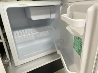 a refrigerator with its door open and a chair inside at COMMA HOUSE Otsuka 102 in Tokyo