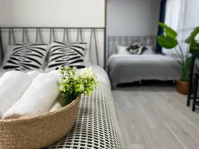 a room with a bed and a basket of towels at COMMA HOUSE Otsuka 102 in Tokyo