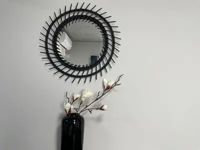 a mirror on a wall with a vase with flowers at COMMA HOUSE Otsuka 102 in Tokyo