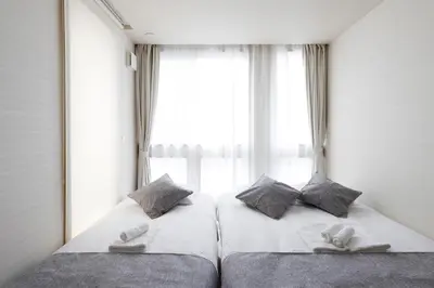 two beds in a room with a window at Second Home KANAMECHO in Tokyo