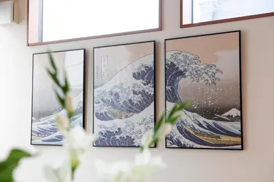 four pictures of the great wave of kanamoto on a wall at Second Home KANAMECHO in Tokyo