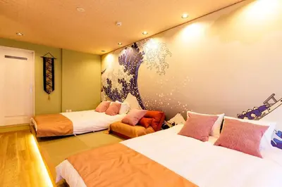 a room with two beds and a painting on the wall at unito \u9752\u7825 in Tokyo