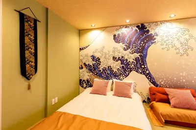a bedroom with a bed with a painting on the wall at unito \u9752\u7825 in Tokyo