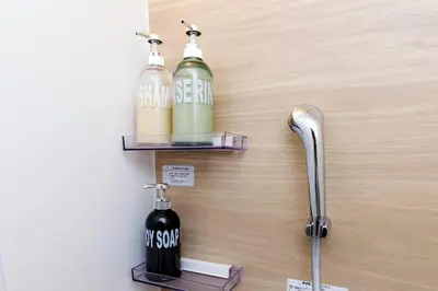 a wall with two alcohol bottles on a shelf at unito \u9752\u7825 in Tokyo