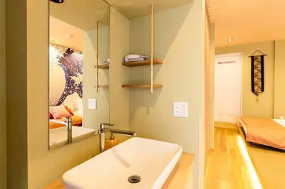 a bathroom with a sink and a bed and a mirror at unito \u9752\u7825 in Tokyo
