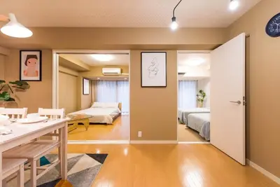 a room with a bedroom and a living room with two beds at unito \u9053\u7384\u5742\u90b8\u5b85 in Tokyo