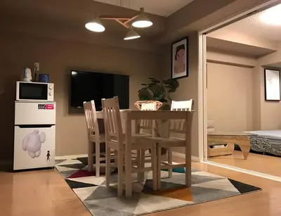 a kitchen with a table and chairs and a television at unito \u9053\u7384\u5742\u90b8\u5b85 in Tokyo