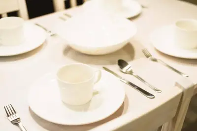 a table with white plates and silverware on it at unito \u9053\u7384\u5742\u90b8\u5b85 in Tokyo