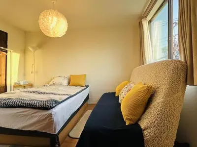 a bedroom with a bed and a couch and a window at \u30b5\u30af\u30e9 in Tokyo