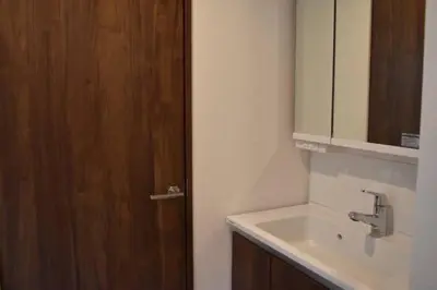 a bathroom with a sink and a wooden door at \u30b5\u30af\u30e9 in Tokyo