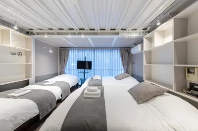 a room with three beds and a tv at \u30b0\u30e9\u30b9\u30ad\u30e3\u30d3\u30f3\u6d5c\u677e\u753aaw Second and third floors in Tokyo