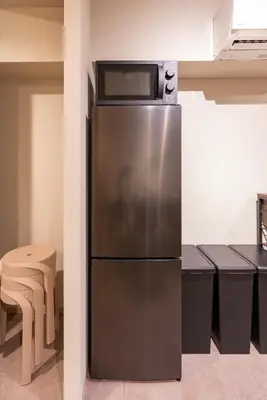 a stainless steel refrigerator in a kitchen with a table at \u30d6\u30e9\u30f3\u30d9\u30fc\u30b9\u6771\u4eac\u516d\u7fa9\u5712 ss in Tokyo