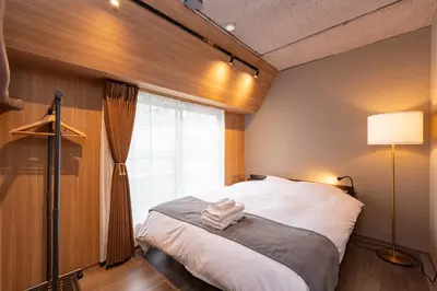 a bedroom with a bed and a window at \u30d6\u30e9\u30f3\u30d9\u30fc\u30b9\u6771\u4eac\u516d\u7fa9\u5712 ss in Tokyo